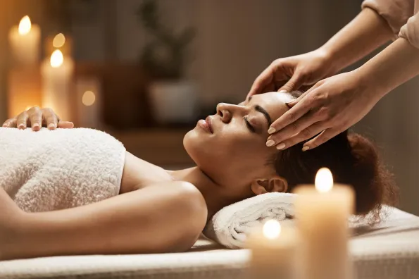 Woman Laying On Massage Table Receiving Scalp Massage