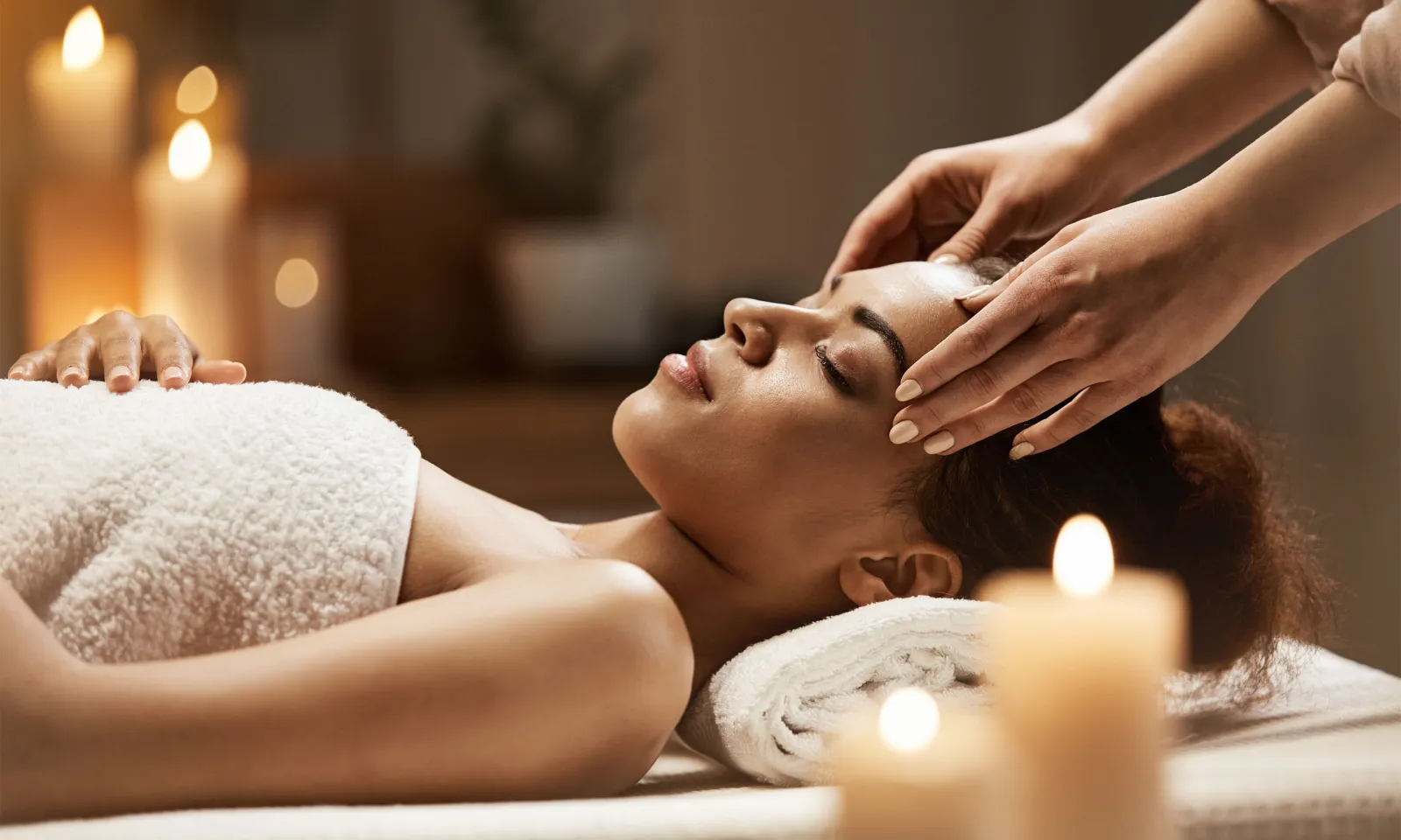 Woman Laying On Massage Table Receiving Scalp Massage