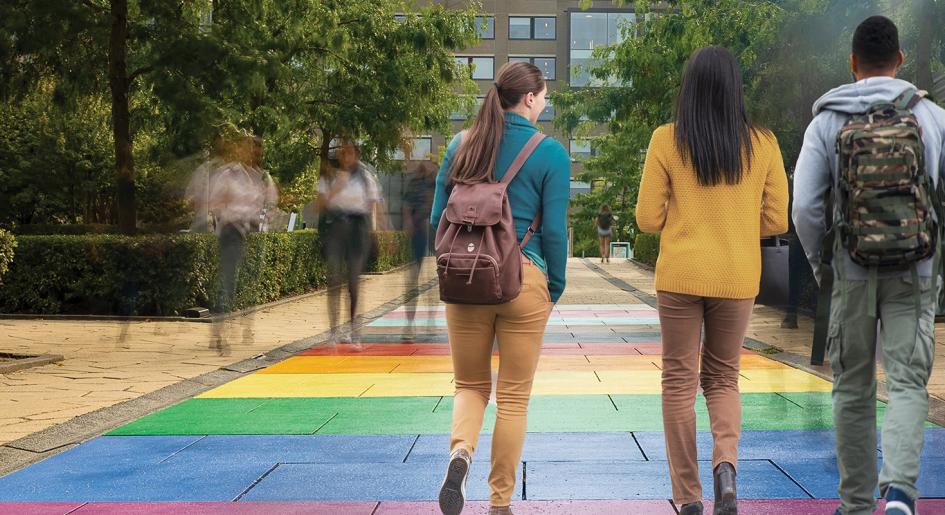 Diverse students walking along rainbox colored sidewalk