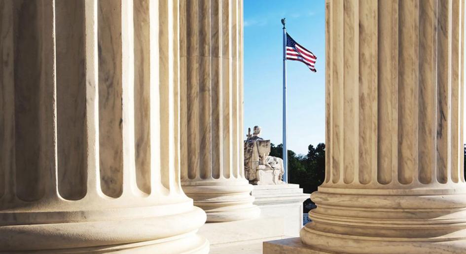 American flag raised between courtroom pillars