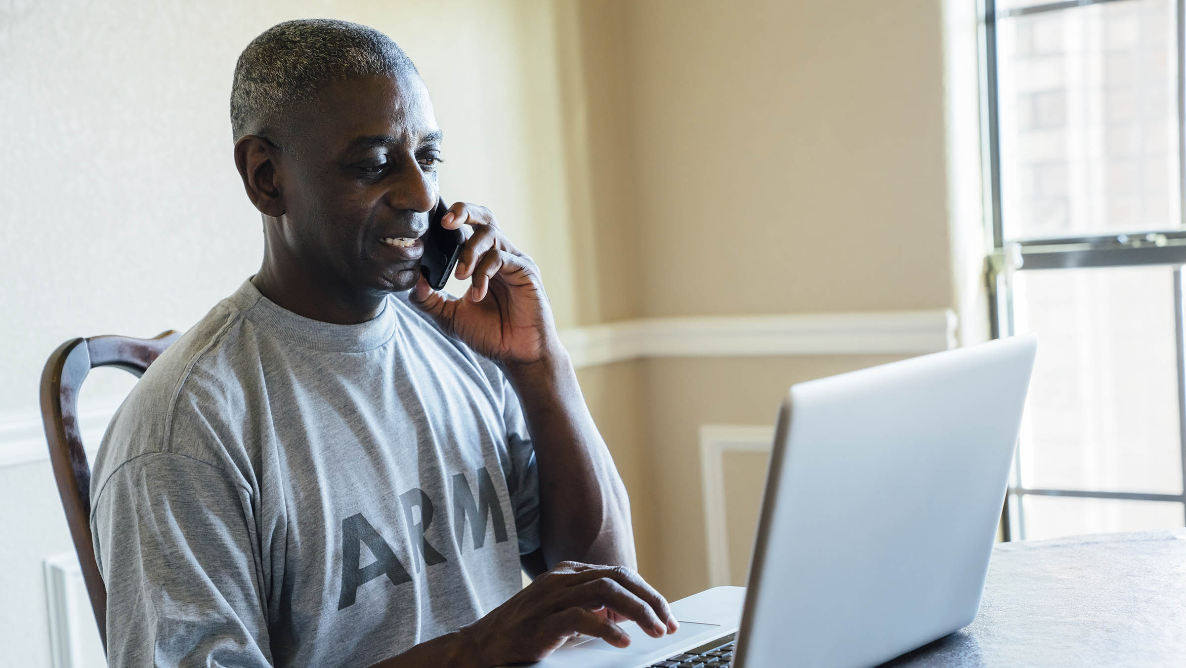 Person using a phone and a laptop