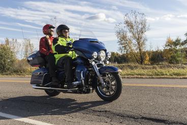 man with woman passenger riding motorcycle on rural highway