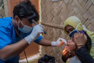 Tayeba Begum, rohingya de 40 años, madre de gemelas, recibe tratamiento para su hija en el ambulatorio del Hospital de la Colina de MSF. Bangladesh.