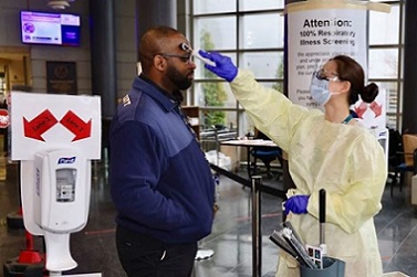 A Veteran having his temperature taken before entering a VA facility