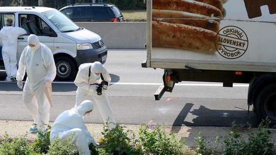 Mehrere Ermittler stehen neben einem Lkw, in dem tote Flüchtlinge entdeckt wurden. © dpa-Bildfunk Foto: Roland Schlager