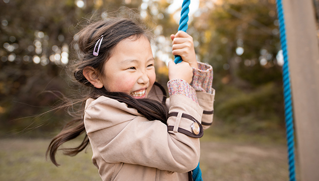 Smiling child on swing - thumbnail