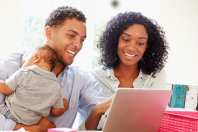 Parents With Baby Working In Office At Home