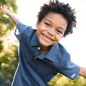 Young child posing with arms out like he is flying.