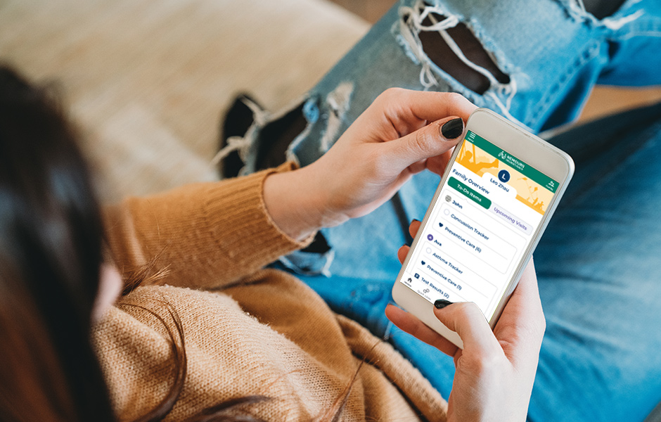 Looking over woman's shoulder while she holds her mobile phone, reading the screen while sitting down