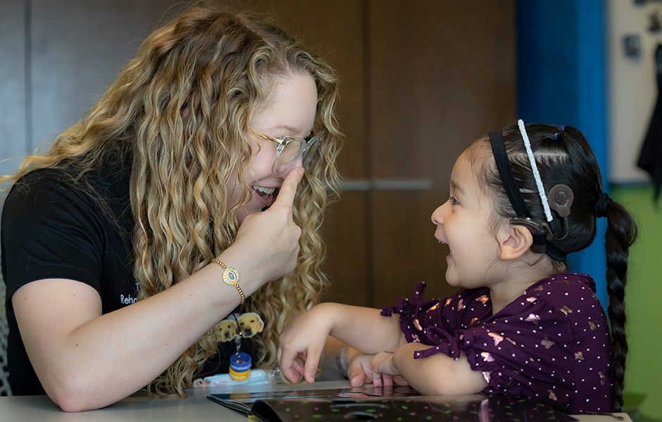 Hearing, communication specialist  interacting with a female child