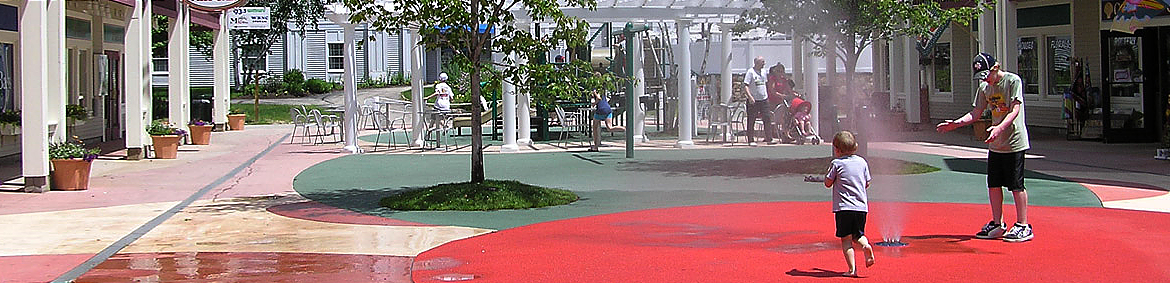 child and adult playing in water spray at an outlet mall