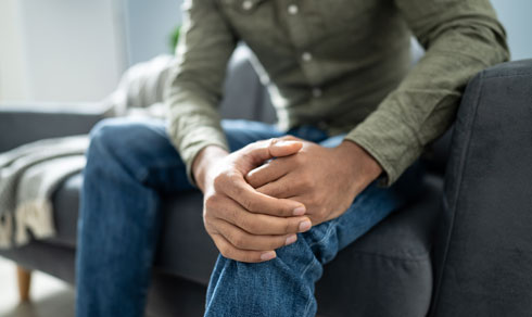 Man sitting down holding his knee.