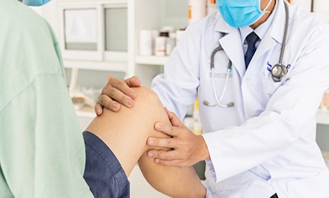 A doctor examines a patient's knee