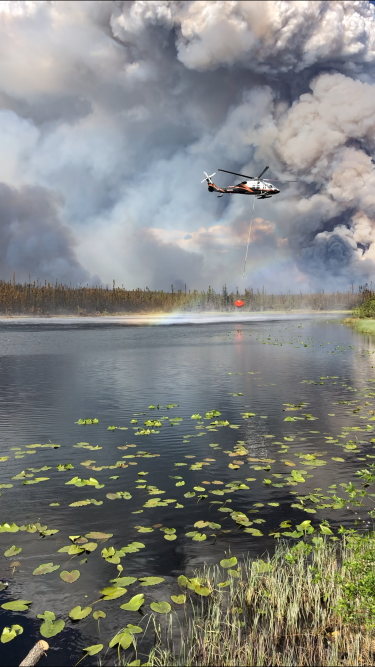 Helicopter collecting water from pond