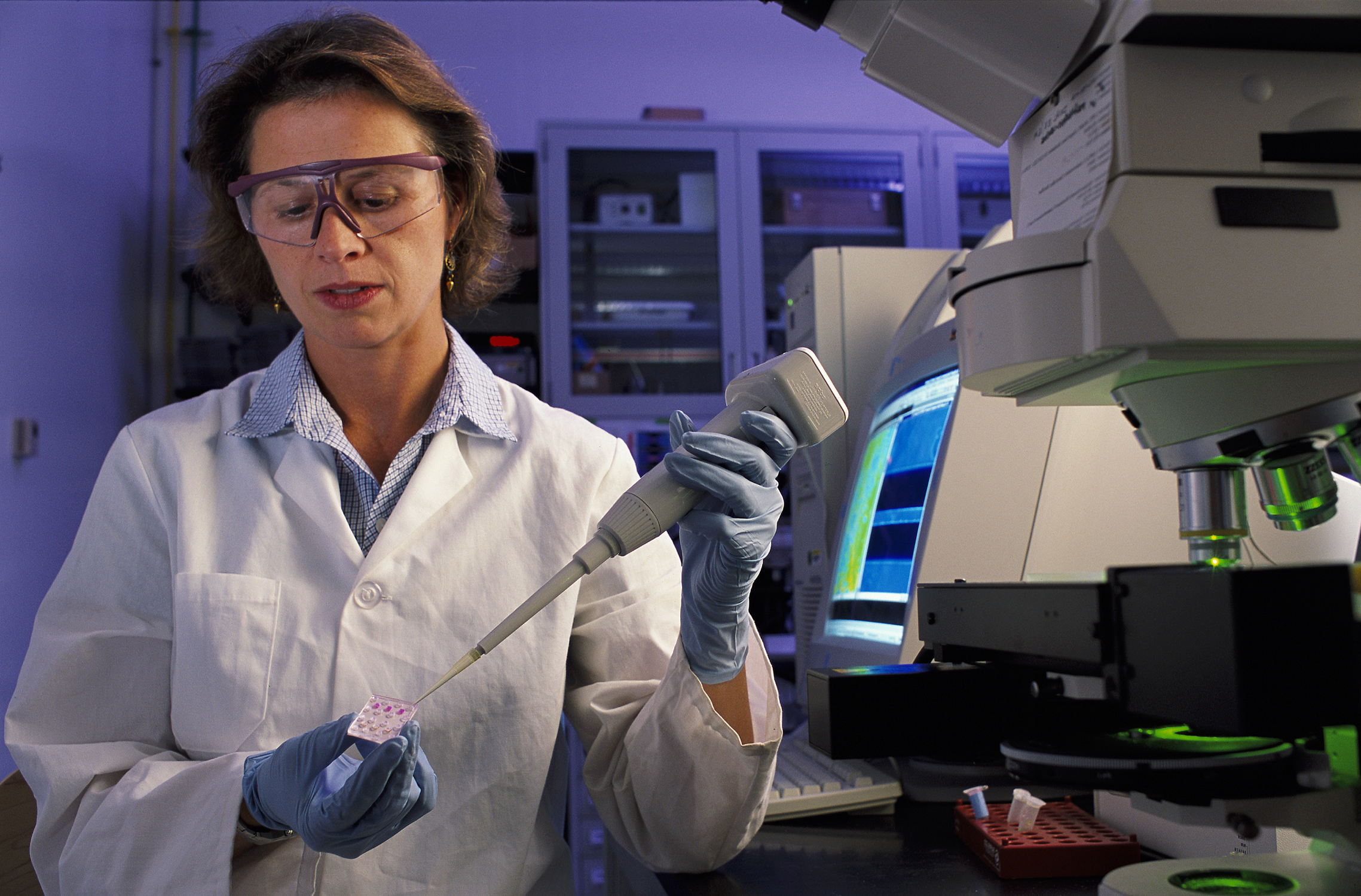 NIST biomedical engineer Laurie Locascio places a water sample on a highly sensitive, inexpensive "lab-on-a-chip"