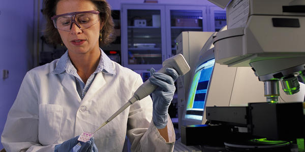 NIST biomedical engineer Laurie Locascio places a water sample on a highly sensitive, inexpensive "lab-on-a-chip"