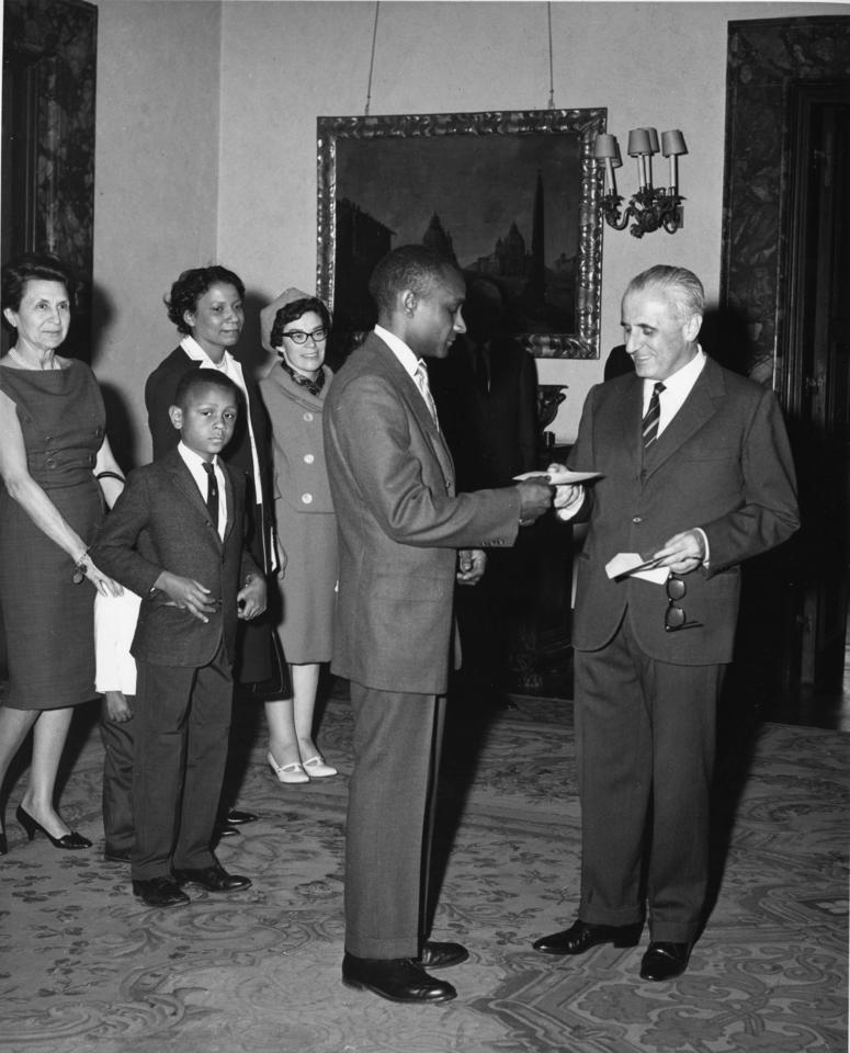 Dolphus Milligan accepting a prize from the Italian ambassador. In the background are his family members.