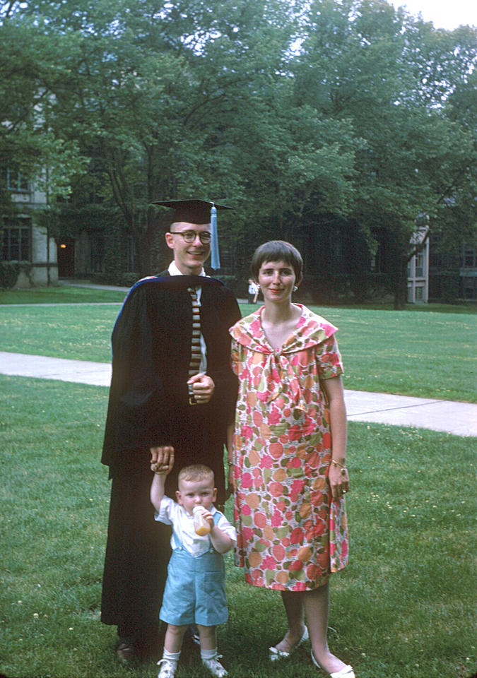 Jan Hall in a cap and gown with his wife and child receiving his PhD