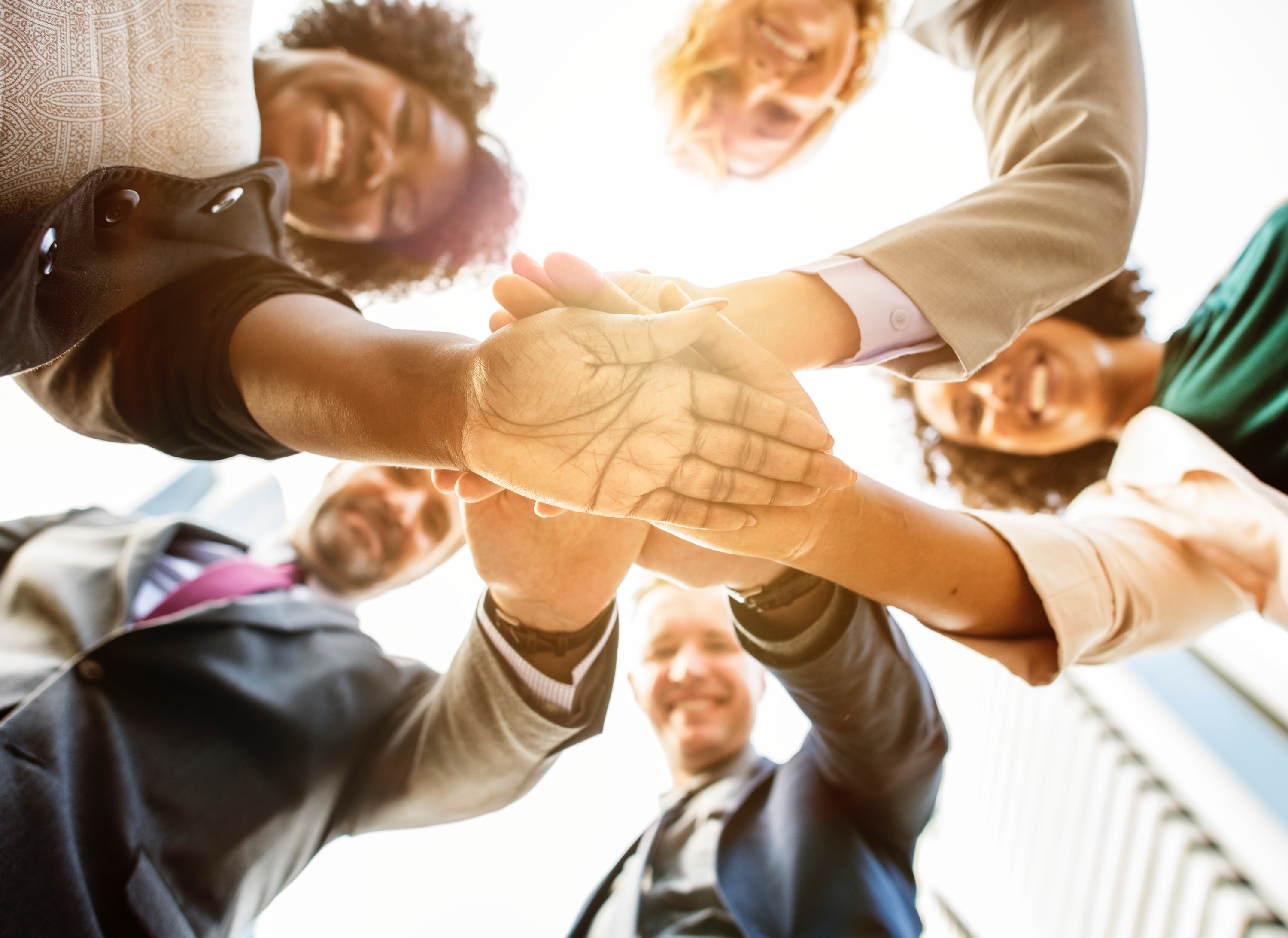 Group of business people creating a huddle. (shutterstock)