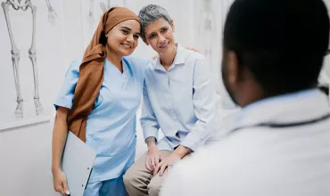 A nurse and patient engaged in a hug