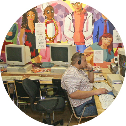 man sitting in computer room with headphones on