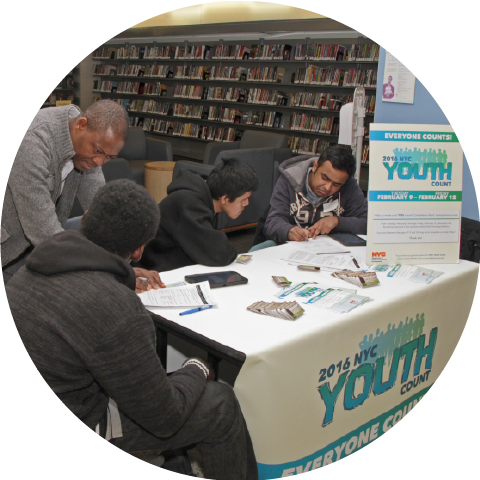 four males at table signup for 2016 NYC Youth Count