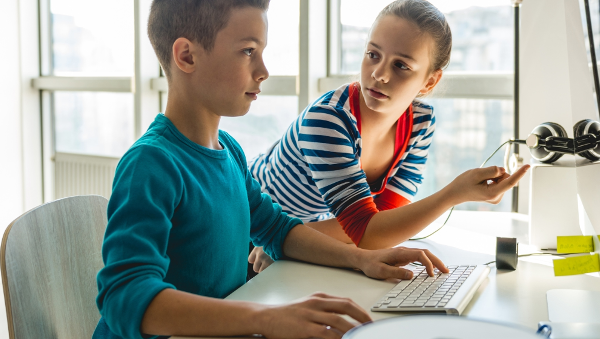 Two children using a desktop computer