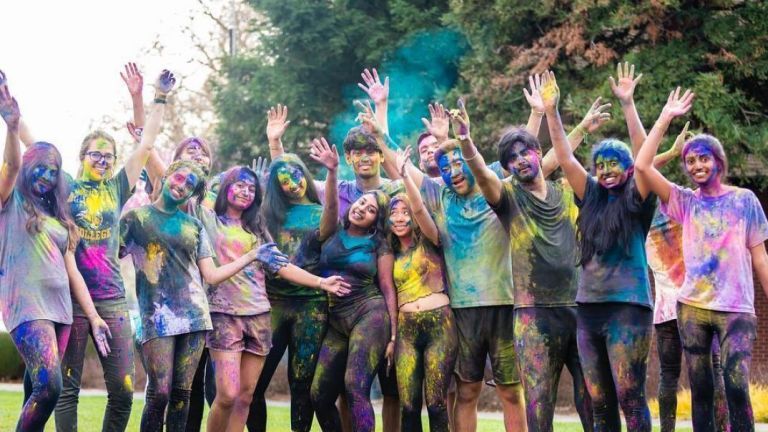 group of students covered in colorful chalk dust