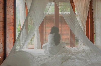 woman under mosquito net