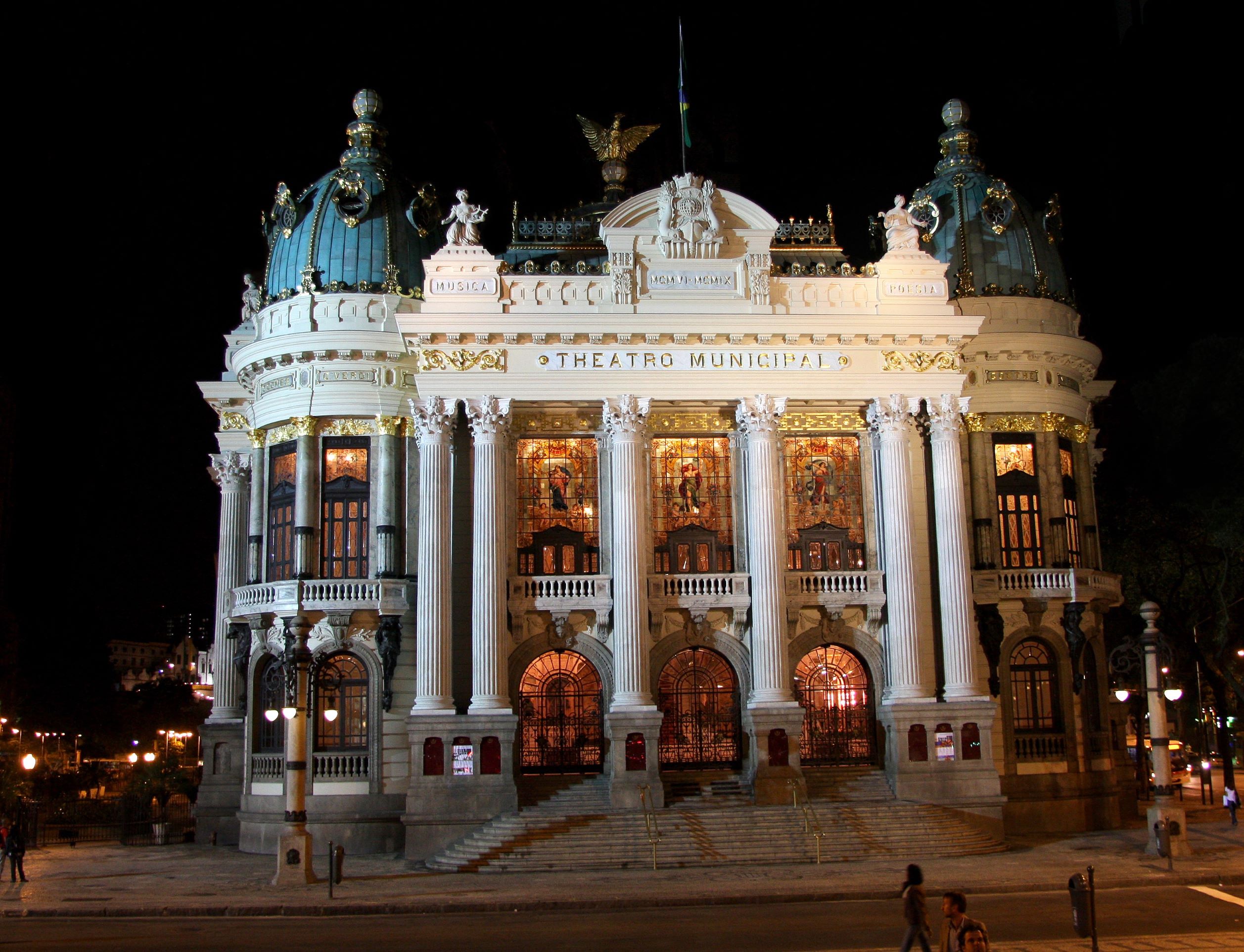 Fotografia noturna da fachada do Theatro Municipal do Rio de Janeiro.