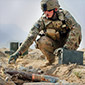 Soldier with munitions laid out to be destroyed