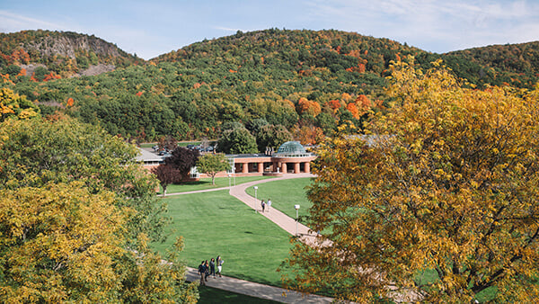 Students cross the Quad with Sleeping Giant in the distance