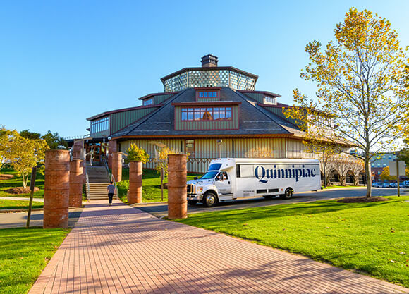 A Quinnipiac shuttle parked outside the Rocky Top Student Center on a fall day