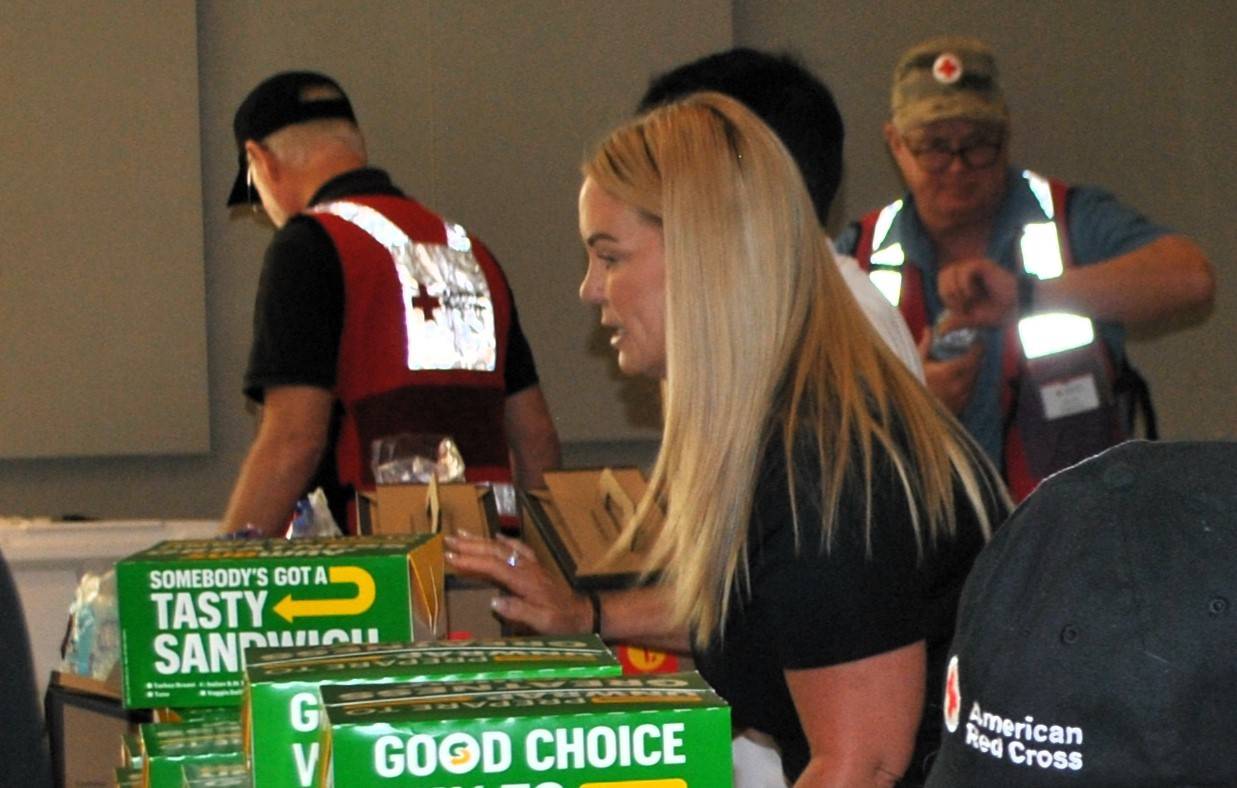 A young Red Cross volunteer helping to provide meals for those affected by the Wildfire