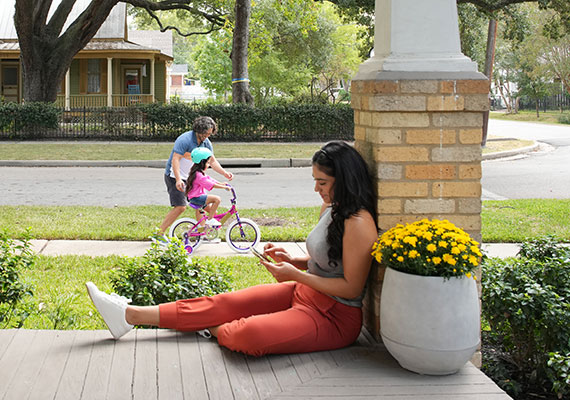 woman on her phone sitting outside on her porch