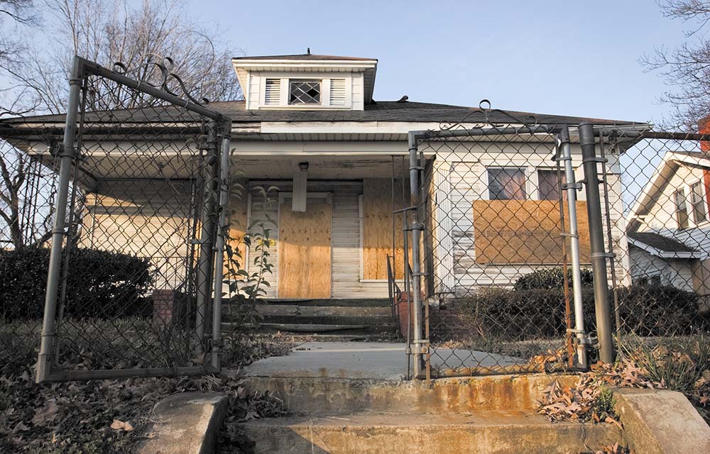 Front of a boarded-up house.