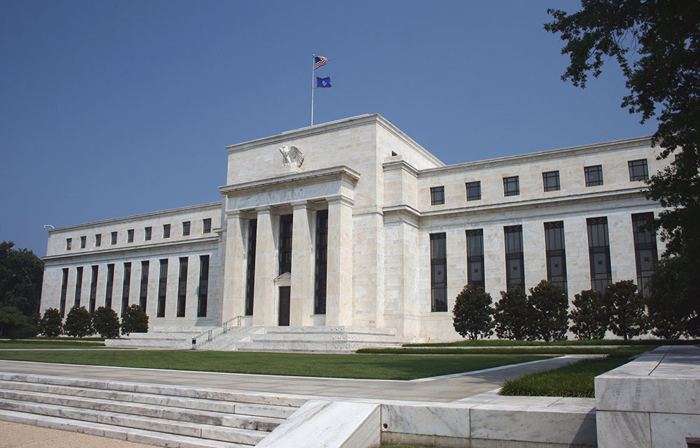 Angled view of the Marriner S. Eccles Federal Reserve Board Building on a sunny day against a blue sky