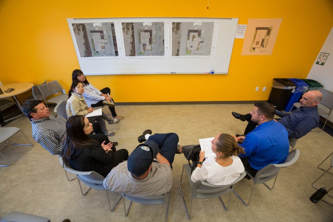 A diverse group meets to discuss community improvements.