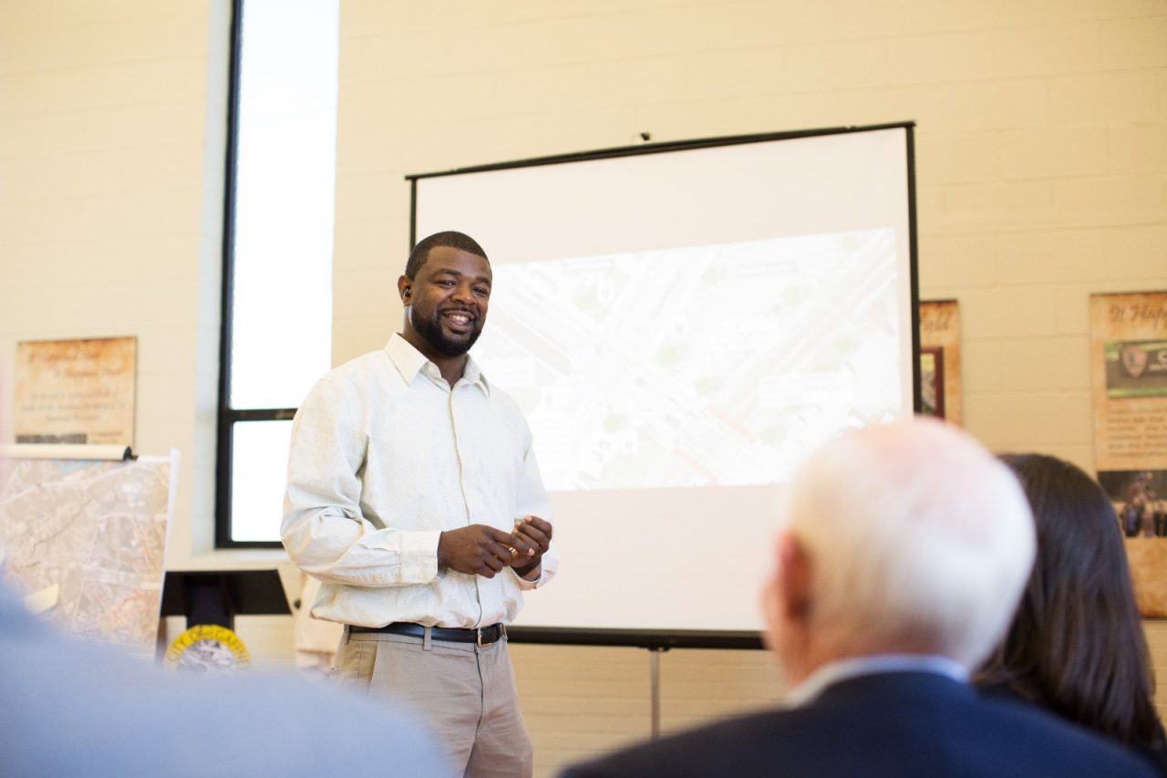 A man presenting with a projector before a group.