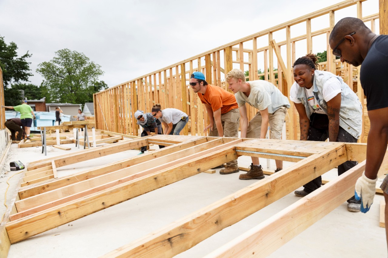 A group of people working on building a house together.