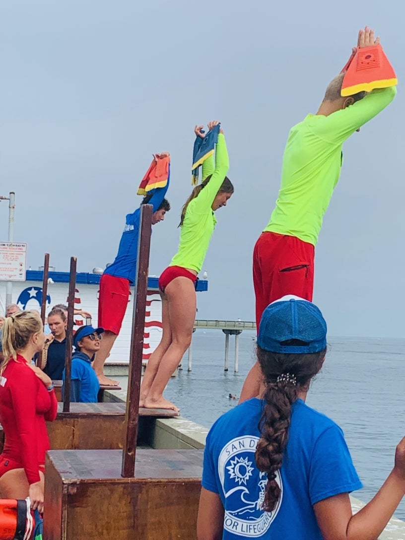 junior lifeguards jumping the pier