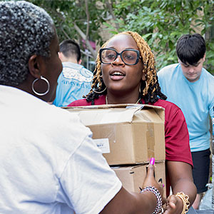 Two people holding a box during move-in 2024