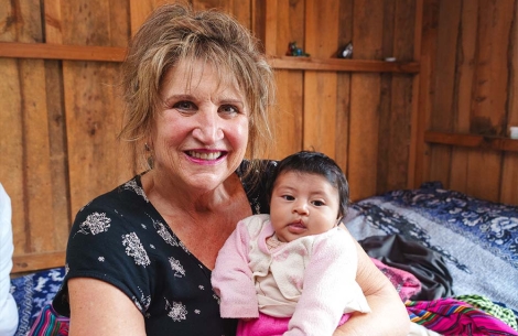 Sue Hoover smiling and holding a cleft-affected baby in Guatemala