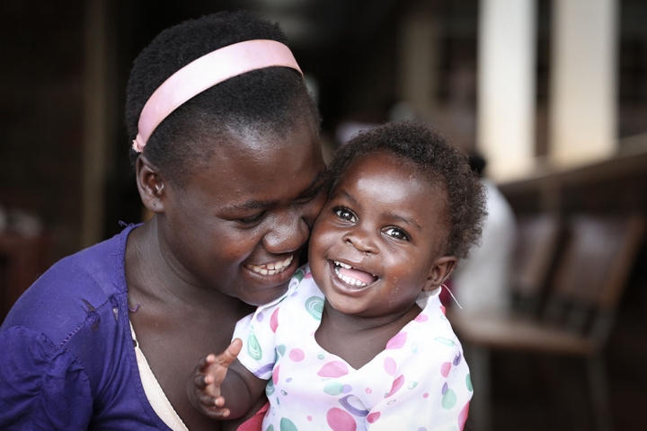 Mother cheek to cheek with daughter after cleft surgery