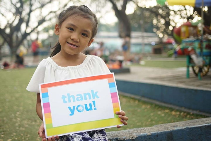 girl holding sign saying thank you