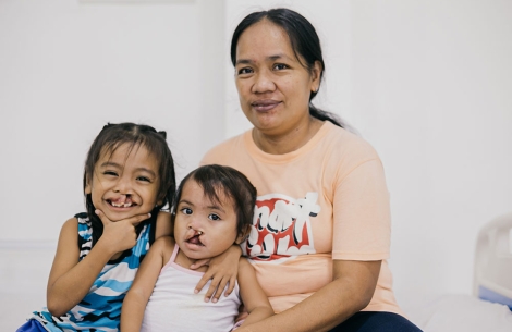 Maricel Pacatang smiling with her daughters Ernie Jr. and Ermalen before their cleft surgeries