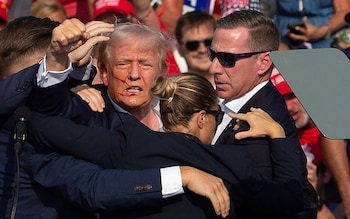 US Republican candidate Donald Trump is seen with blood on his face surrounded by secret service agents