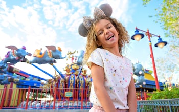 Child standing in front of Dumbo The Flying Elephant ride at Disney's Magic Kingdom Park