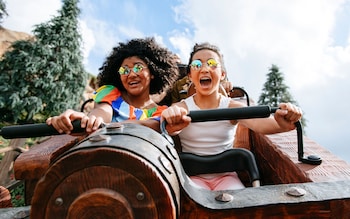Two girls ride the Seven Dwarfs Mine Train in the Magic Kingdom, Walt Disney World Resort, Florida