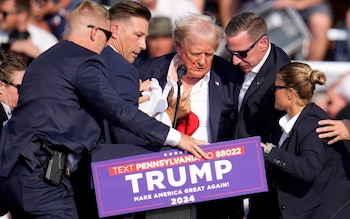 Donald Trump is helped off the stage at a rally after being hit by a bullet